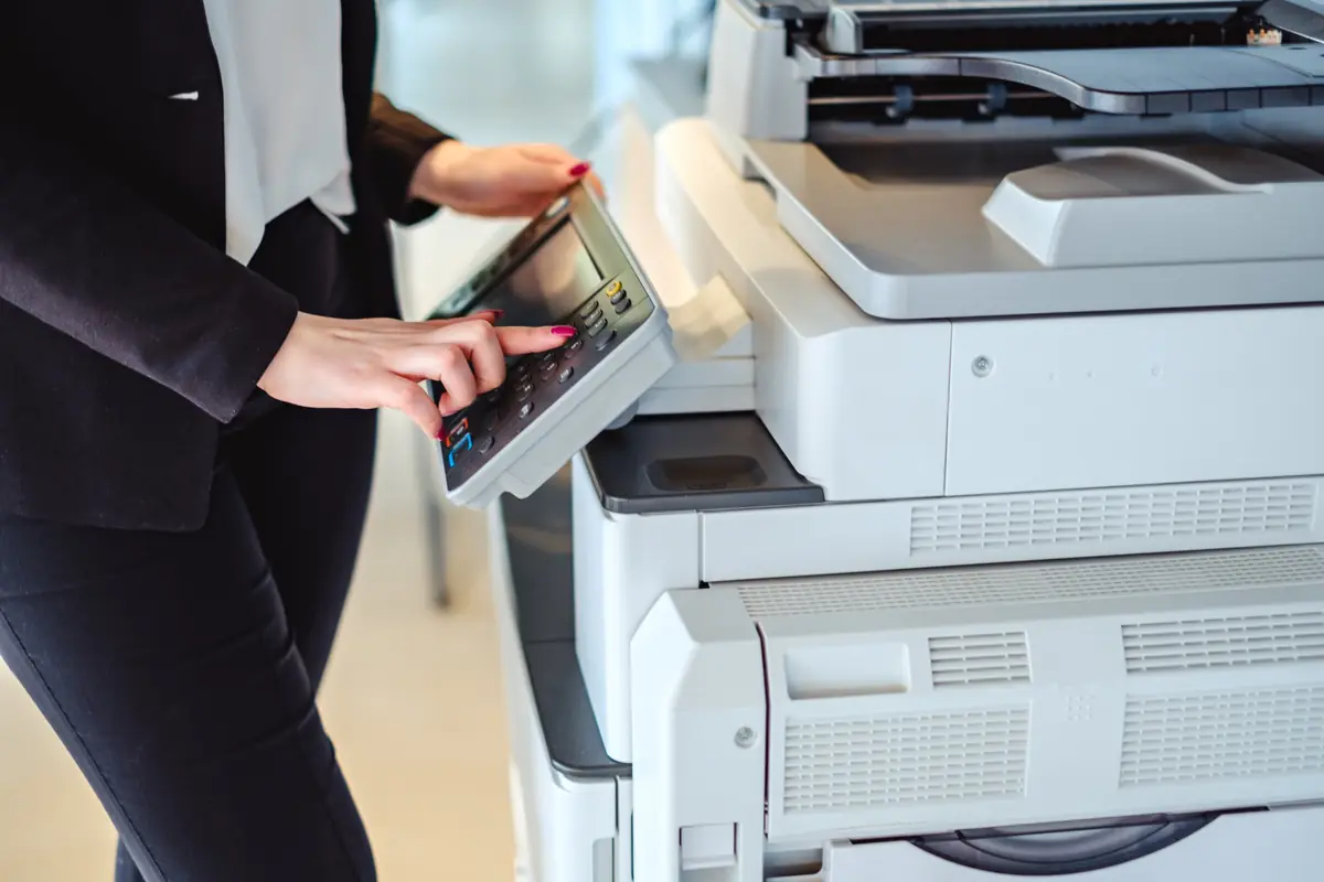 Office worker entering a code on a multifunction copier's control panel