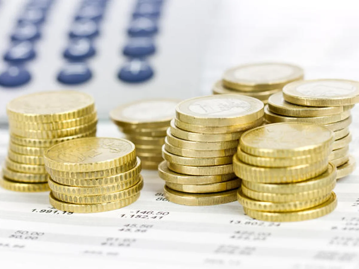 Stacks of gold coins beside a calculator, representing predictable monthly lease payments